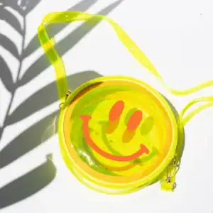 Yellow round bag with smiley face design.