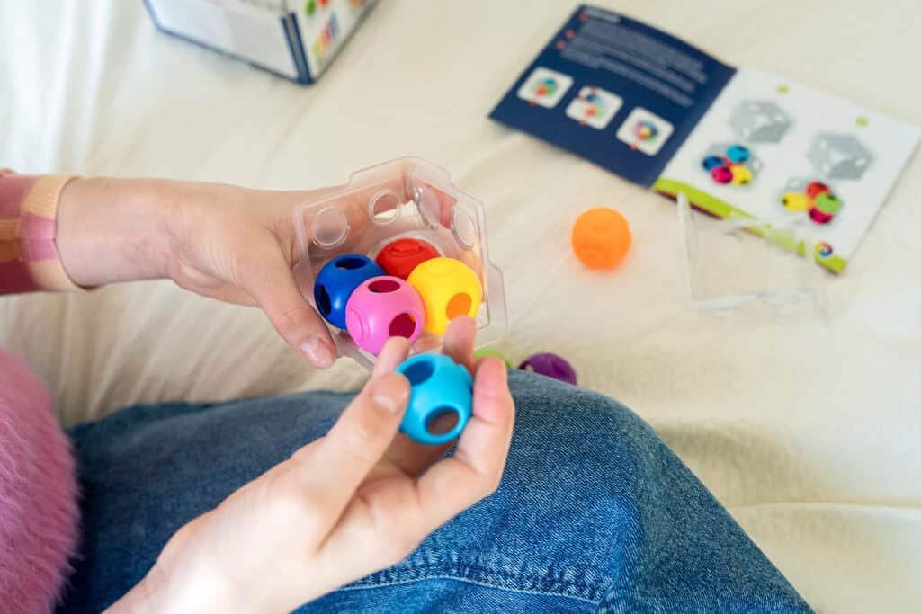 Hands playing with colorful educational toy blocks.