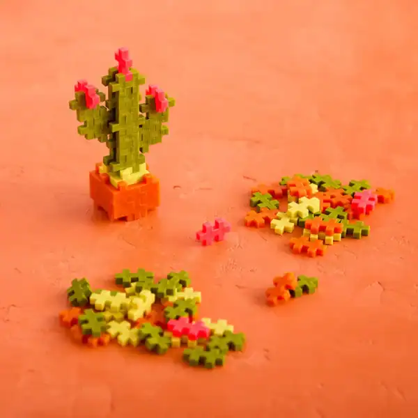 Colorful cactus toy blocks on orange surface.