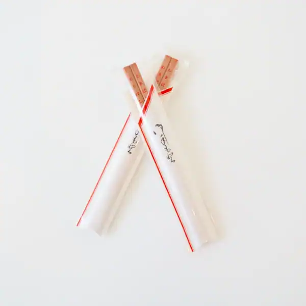 Two wrapped wooden chopsticks on white background.