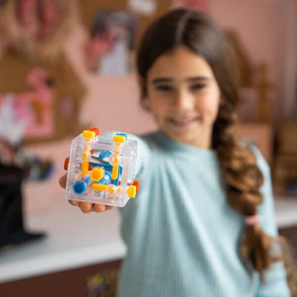 Girl holding a geometric puzzle toy.