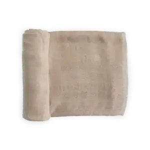 Rolled beige muslin fabric on black background.