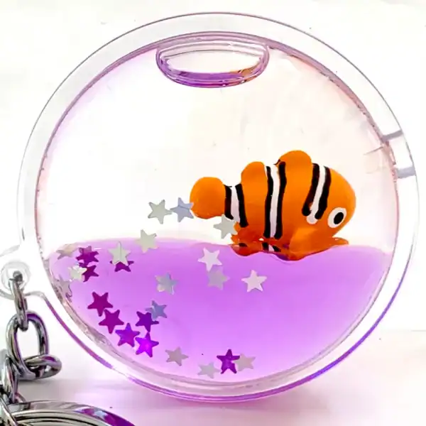 Keychain with clownfish and purple liquid.