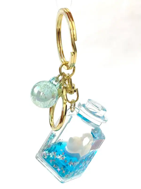 Blue starry jar keychain with gold rings.