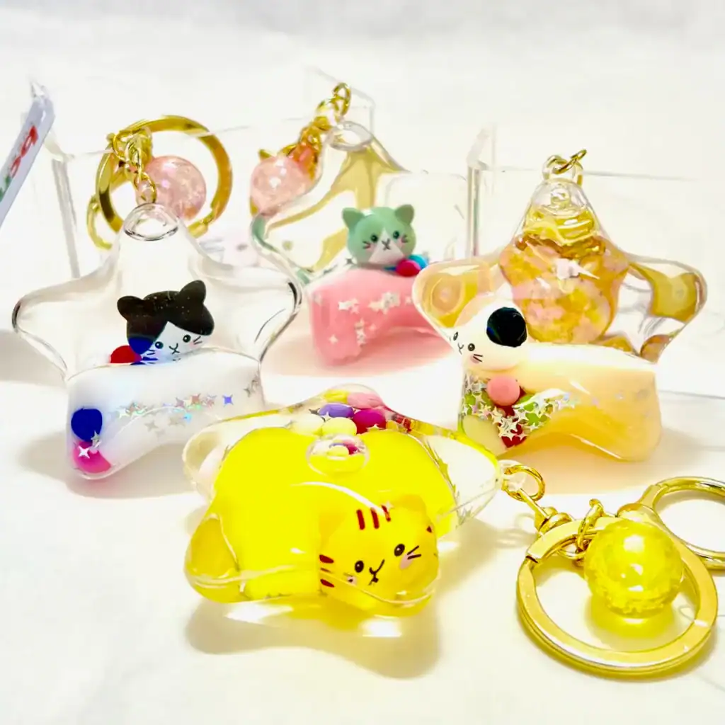 Star-shaped keychains with colorful cat designs.