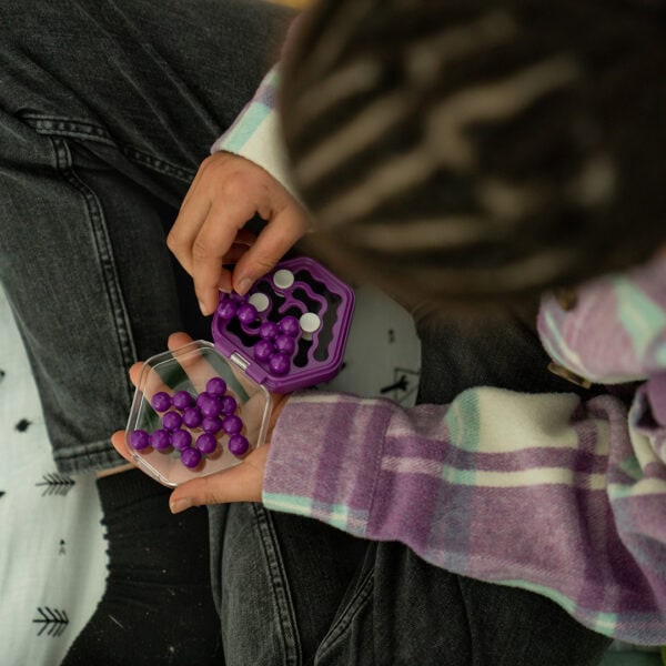 Child playing with purple puzzle game on floor.