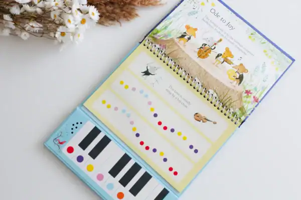 Children's music book with piano keys and notes.