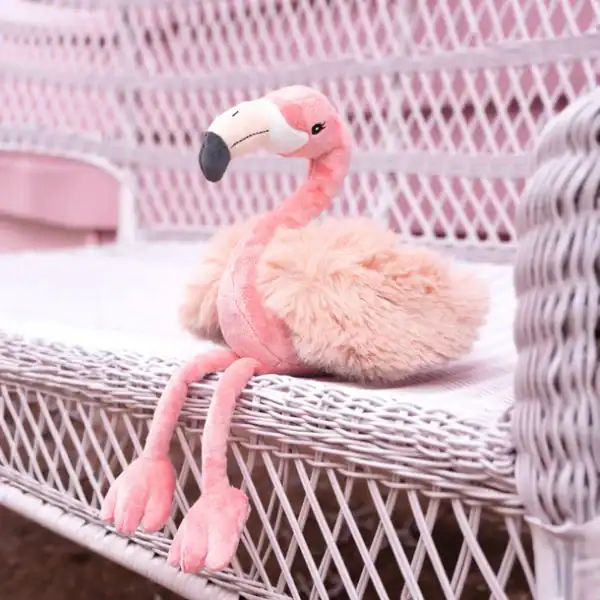 Plush flamingo toy on wicker chair
