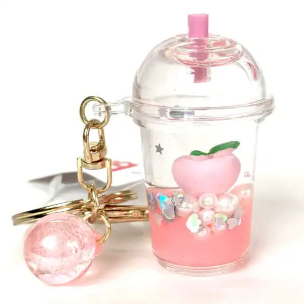 Pink peach-themed keychain with glitter.