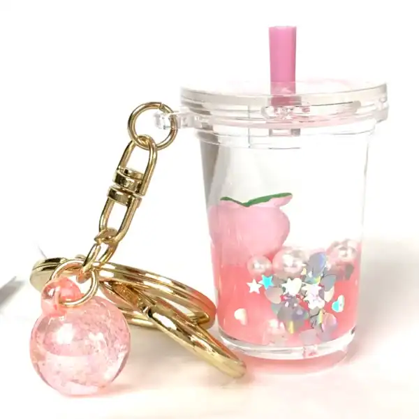 Pink peach bubble tea keychain with gold details.