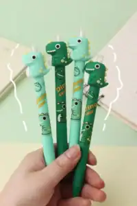 Colorful dinosaur pens held in a hand