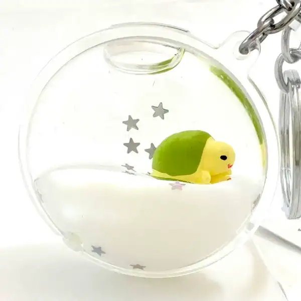 Cute turtle keychain with star decorations in capsule.
