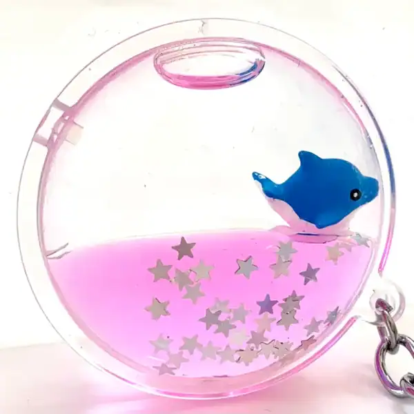 Dolphin keychain with stars, pink liquid-filled.