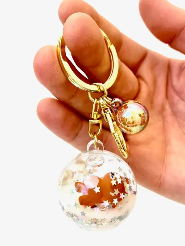 Cute keychain with floating bear and star confetti.