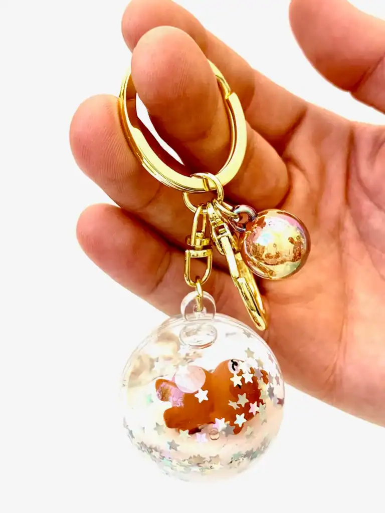 Cute keychain with floating bear and star confetti.