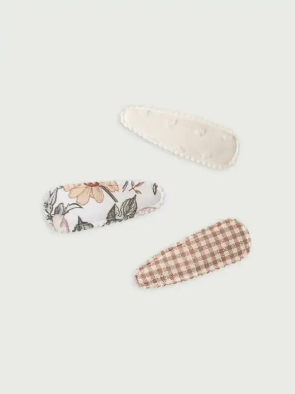 Three fabric hair clips with floral and checkered designs.