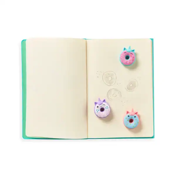 Open notebook with unicorn donut magnets and sketches.