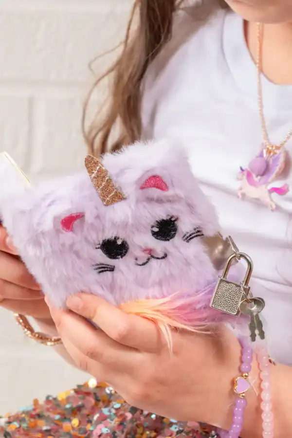 Child holding a fuzzy unicorn diary with a lock.