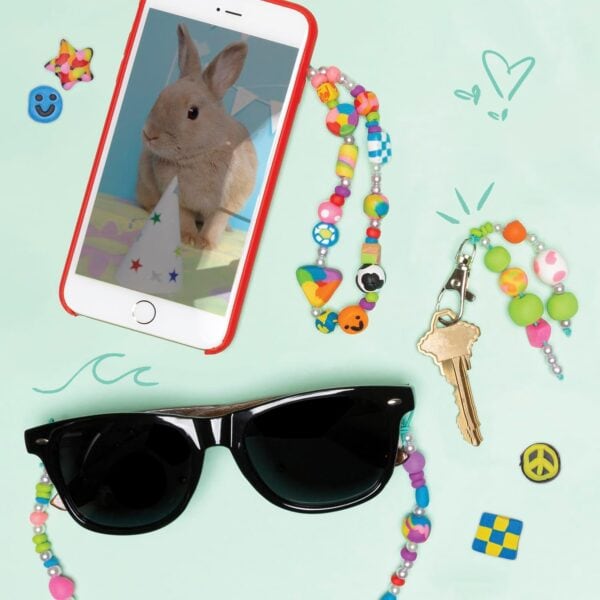 Sunglasses, smartphone with bunny, keys, and beads accessory.