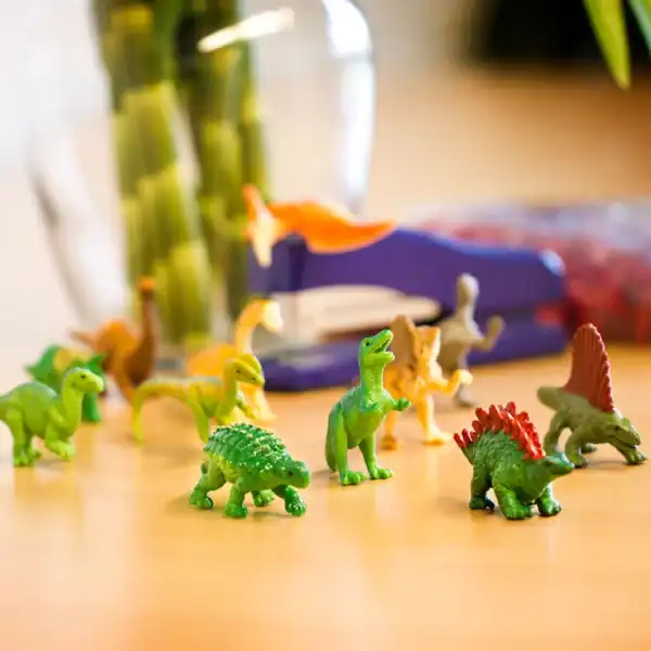 Colorful toy dinosaurs on a table.