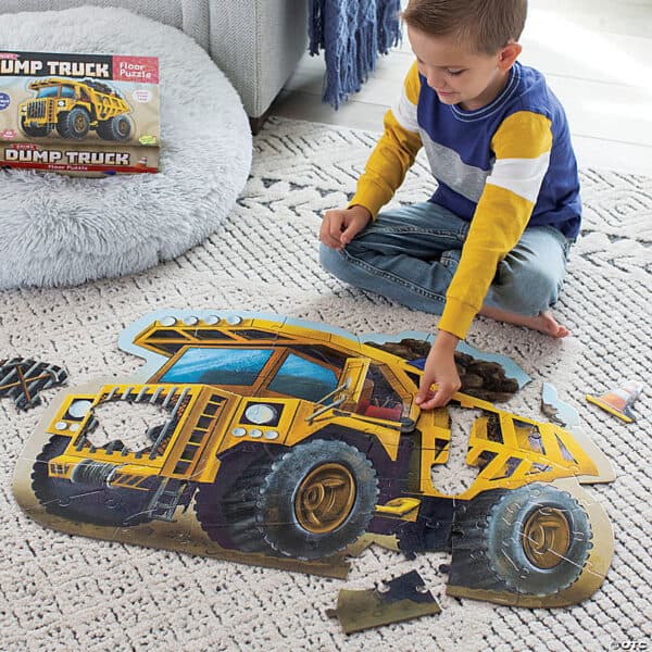Child assembling dump truck puzzle on rug