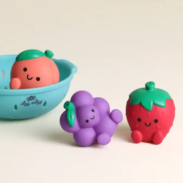 Cute fruit-shaped bath toys with smiling faces.