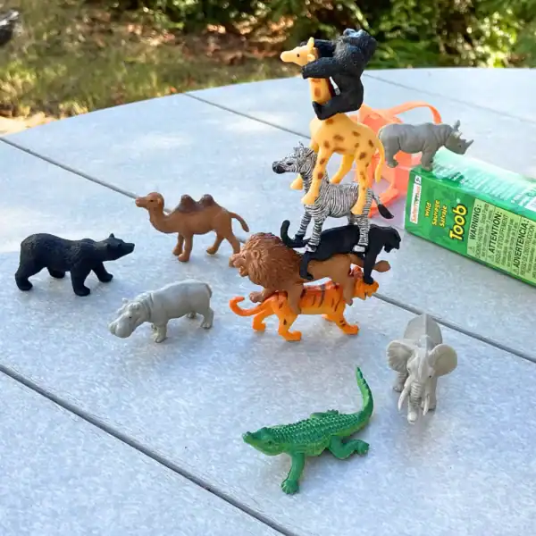Toy animal figures stacked and arranged on table.
