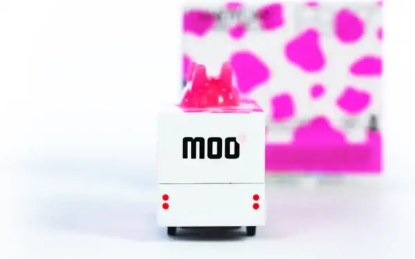 Model truck with pink cow spots and 'moo' text.