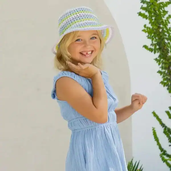 Smiling girl in blue dress wearing a hat