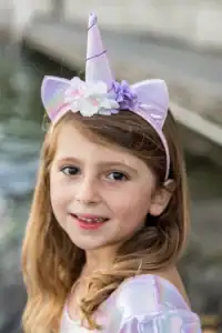 Child wearing unicorn headband outdoors
