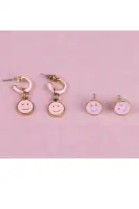 Pink smiley face earrings on pink background.