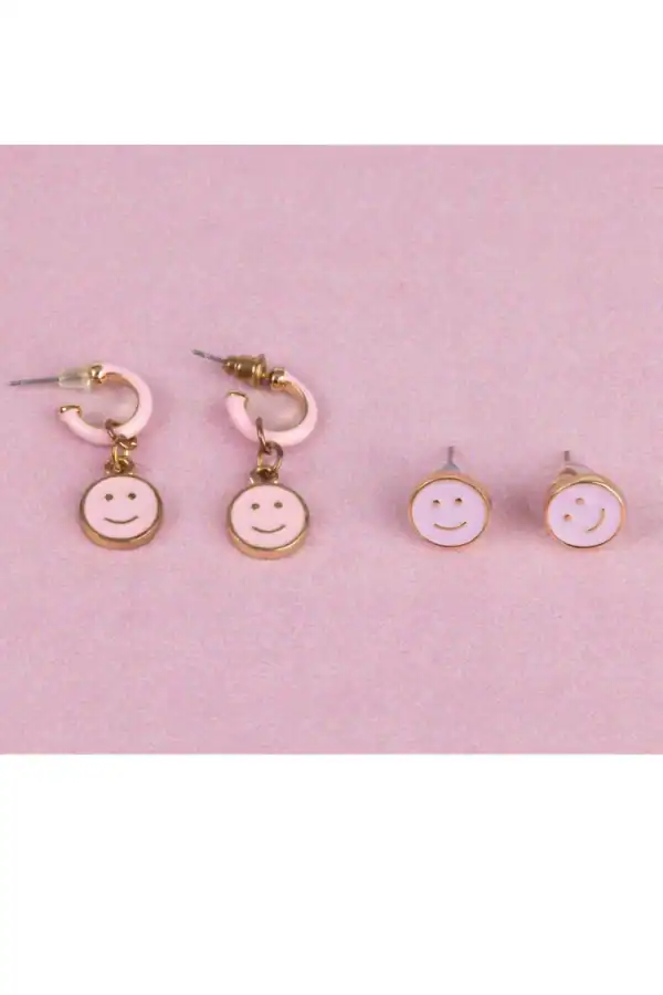 Pink smiley face earrings on pink background.