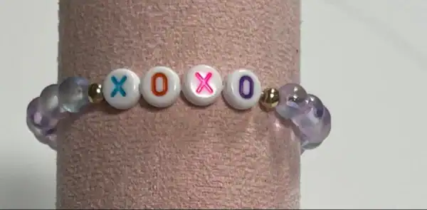 Bracelet with XOXO beads and purple crystals.