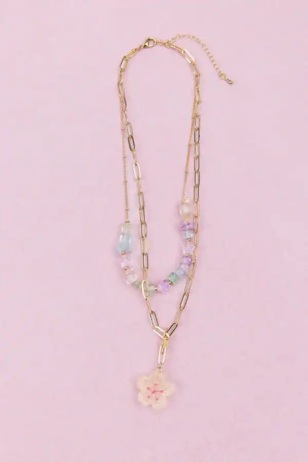 Gold chain necklace with pastel beads and flower pendant.