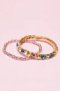 Colorful gemstone bracelets on pink background