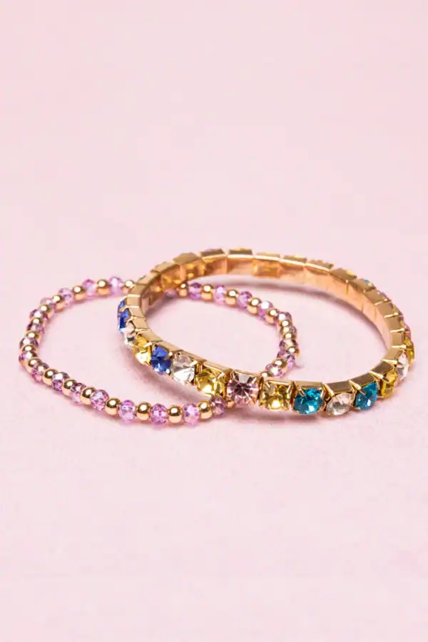 Colorful gemstone bracelets on pink background