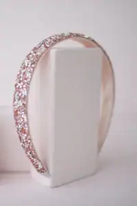 Sparkling pink gemstone headband on white stand