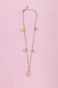 Gold necklace with colorful heart charms on pink background.