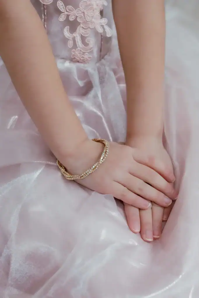 Child hands on pink dress with bracelet
