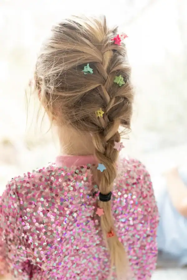 Girl's braided hair with colorful star clips.