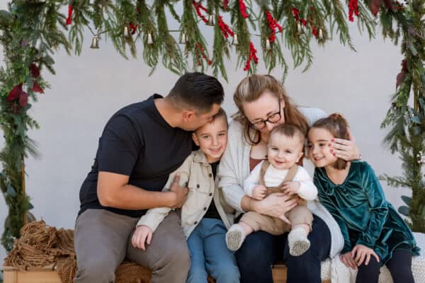 Family sitting together under festive garland.