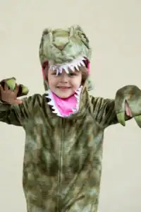 Child in dinosaur costume with pink interior.