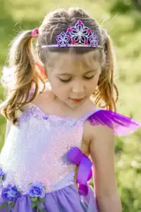 Child in sparkly dress with tiara outdoors