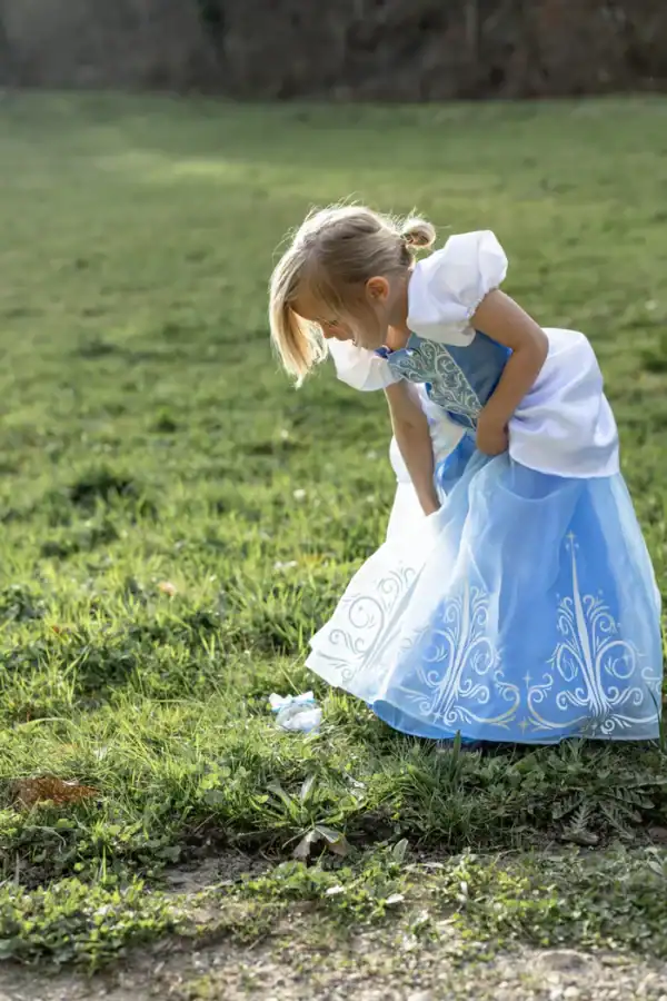 Child in princess dress outdoors on grass