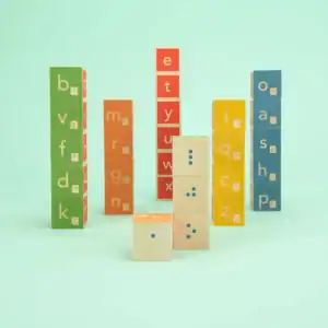 Colorful wooden alphabet and Braille blocks stacked high.