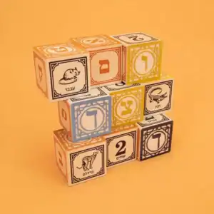 Colorful Hebrew alphabet blocks stacked on orange background.