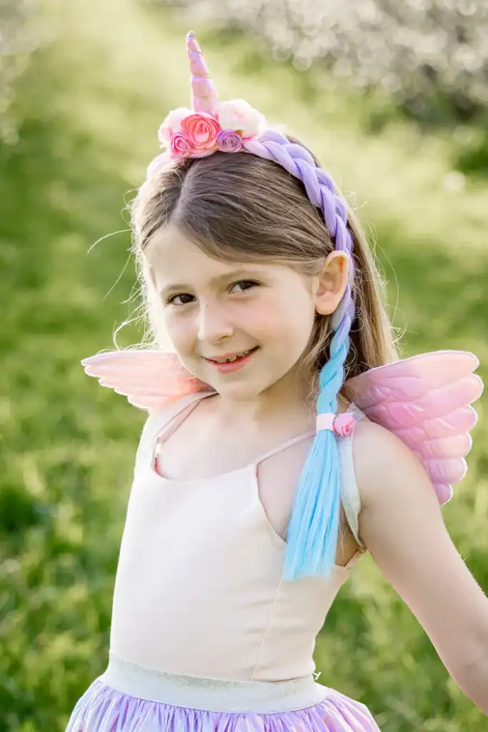 Girl in unicorn costume smiling outdoors