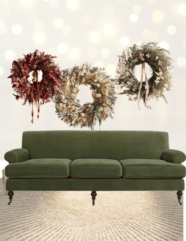 Three festive wreaths above green sofa on rug.