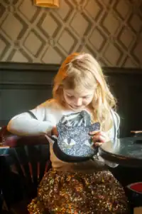 Child looking into a glittery cat-shaped bag.