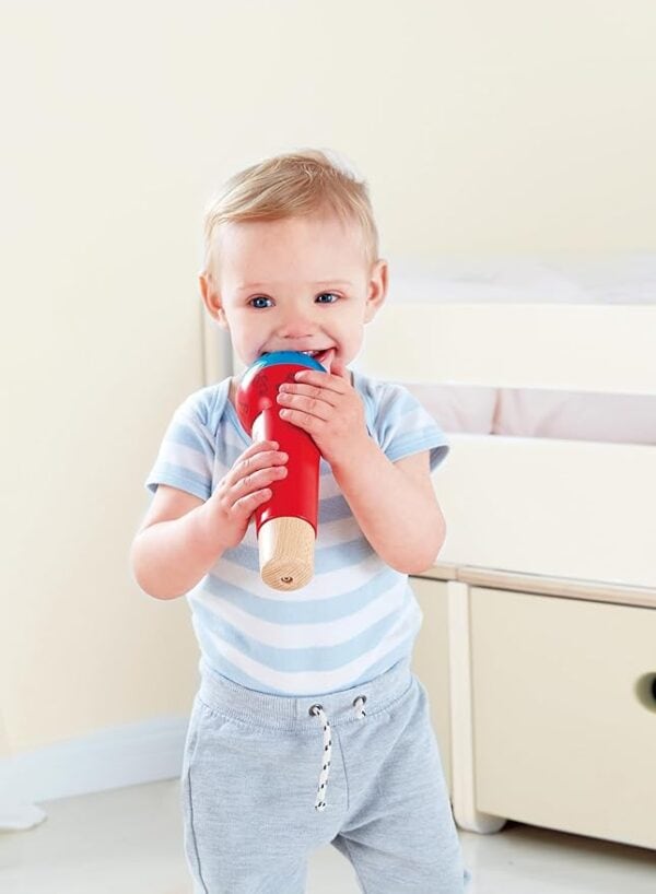 Toddler playing with a red toy microphone.
